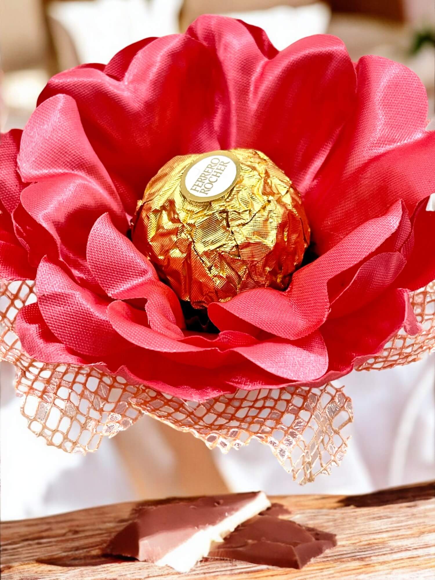 Ferrero Rocher chocolate in a coral flower. The flower encases the chocolate. It is a fabric flower sweet holder.