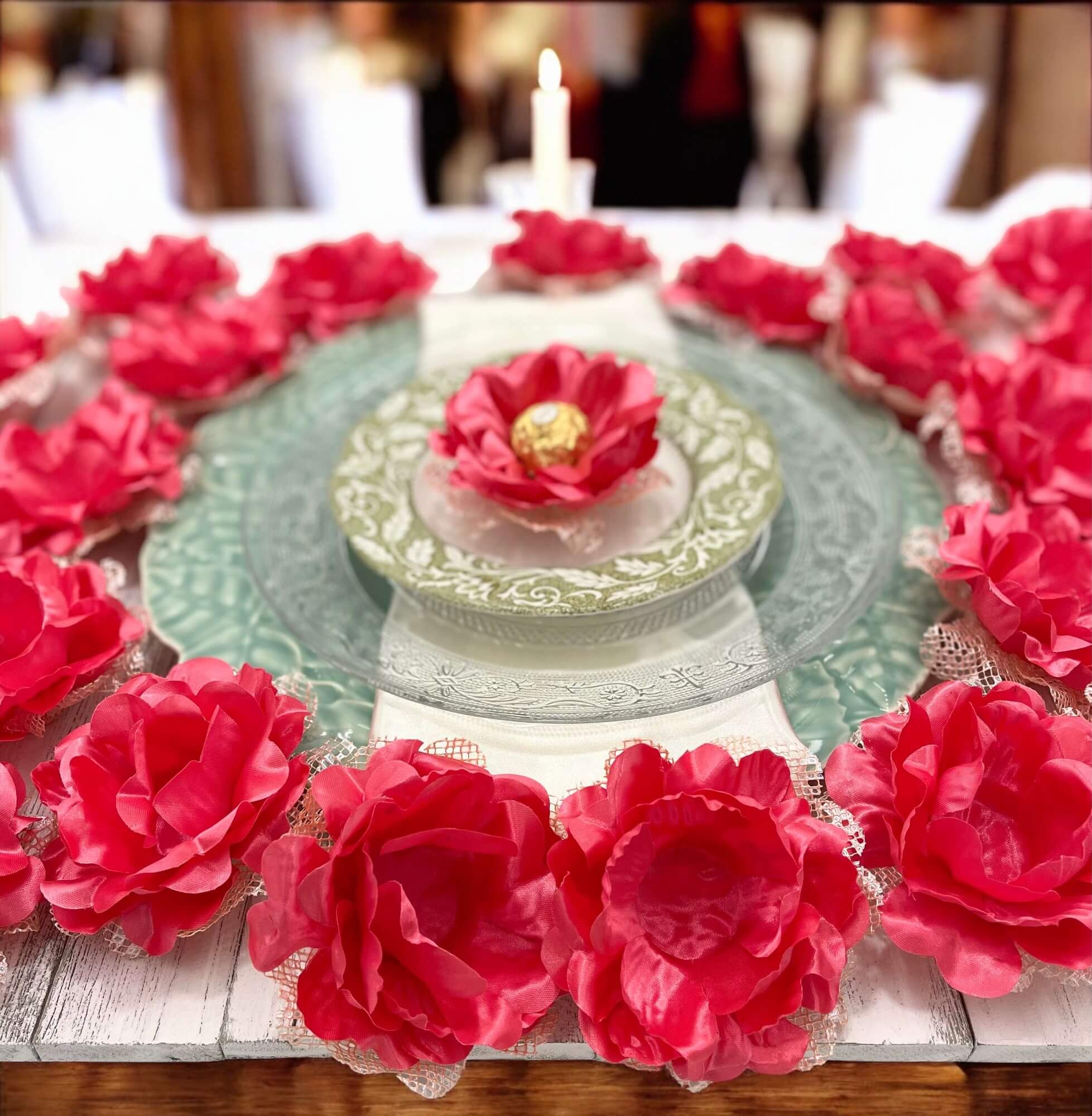 coral flower-shaped containers with gold chocolates on a wooden surface.