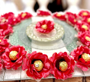 Decorative coral flowers with gold centers on a wooden surface