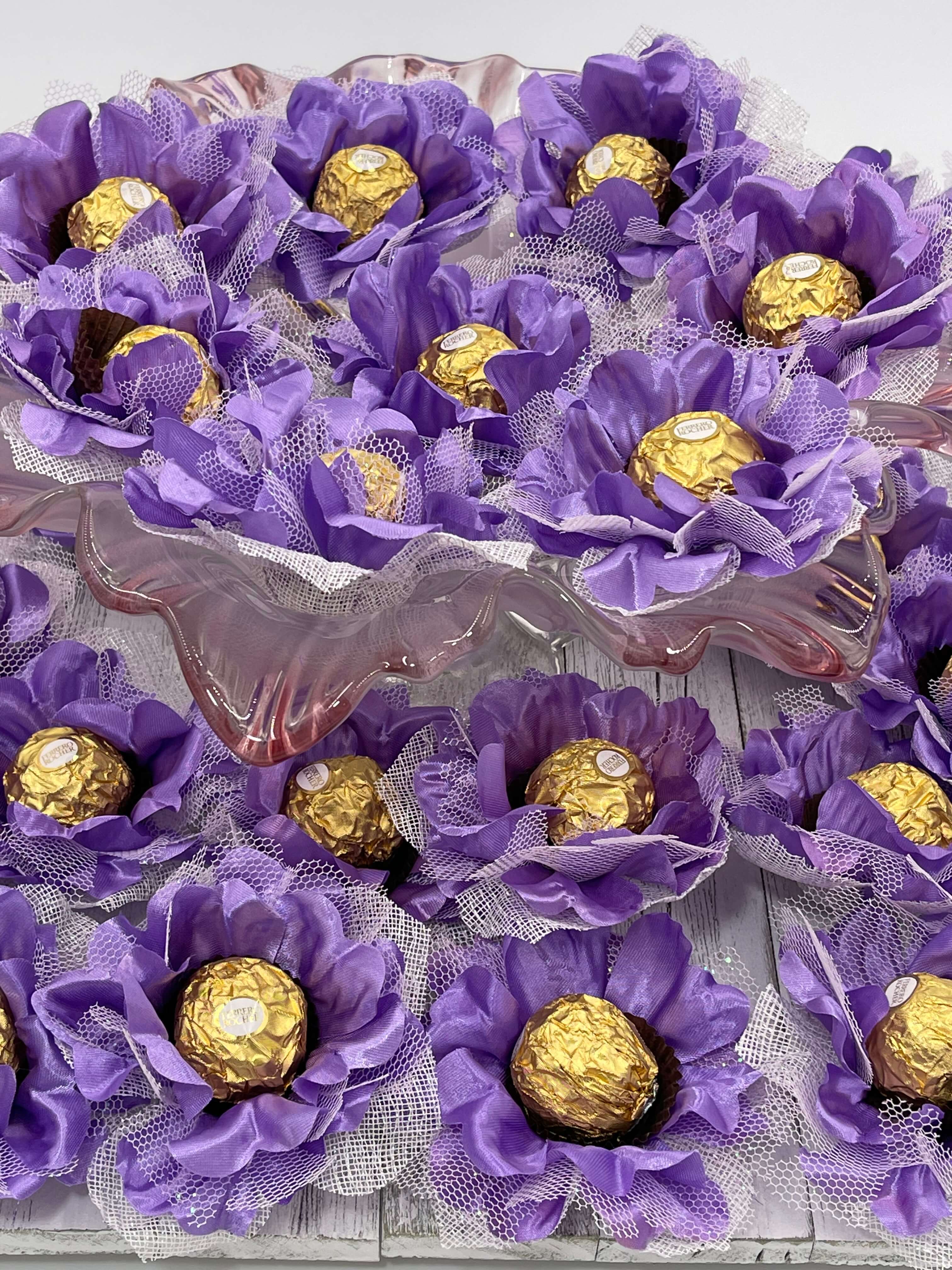 A close-up of purple silk flowers with gold chocolate, designed for events and parties.