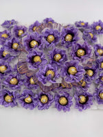 A close-up of purple silk flowers with gold chocolate, designed for events and parties.