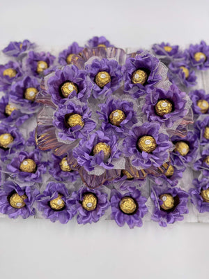 A close-up of purple silk flowers with gold chocolate, designed for events and parties.