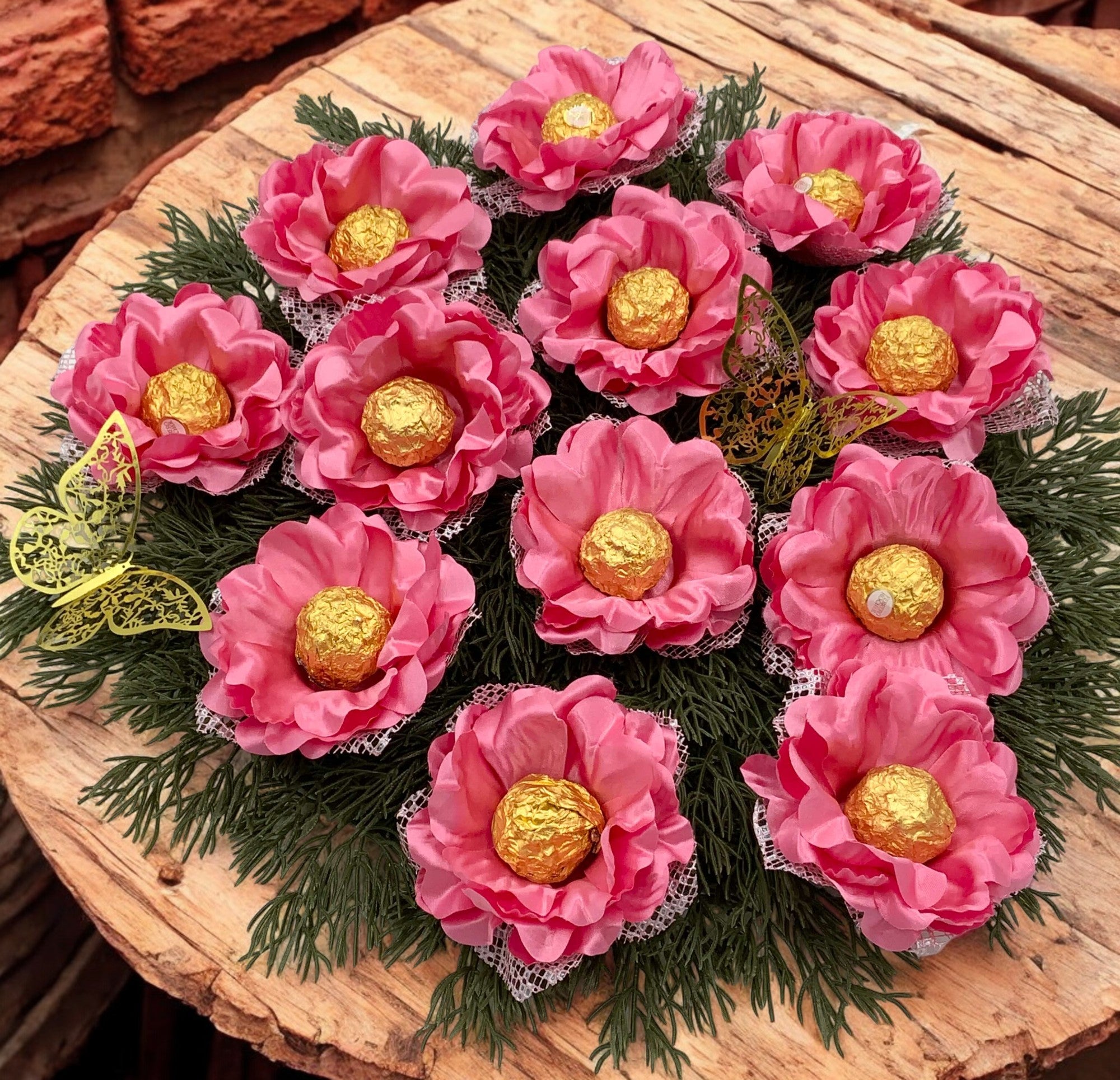 Bouquet of pink flowers with gold centers on a wooden surface