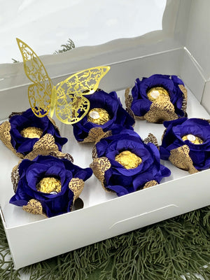 Decorative items with blue flowers and gold accents in a white box.