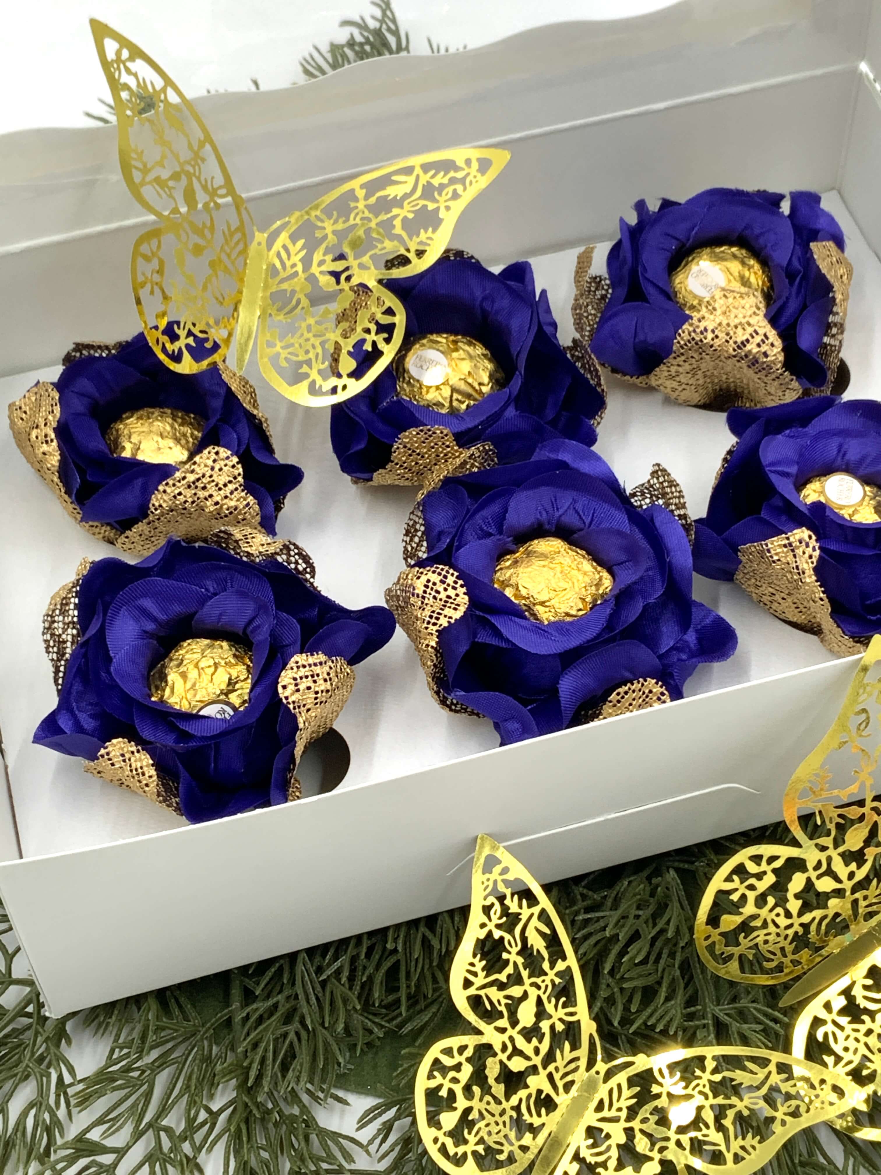 Decorative items with  royal blue flowers and gold accents in a white box, featuring butterfly decorations.