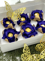 Decorative items with  royal blue flowers and gold accents in a white box, featuring butterfly decorations.